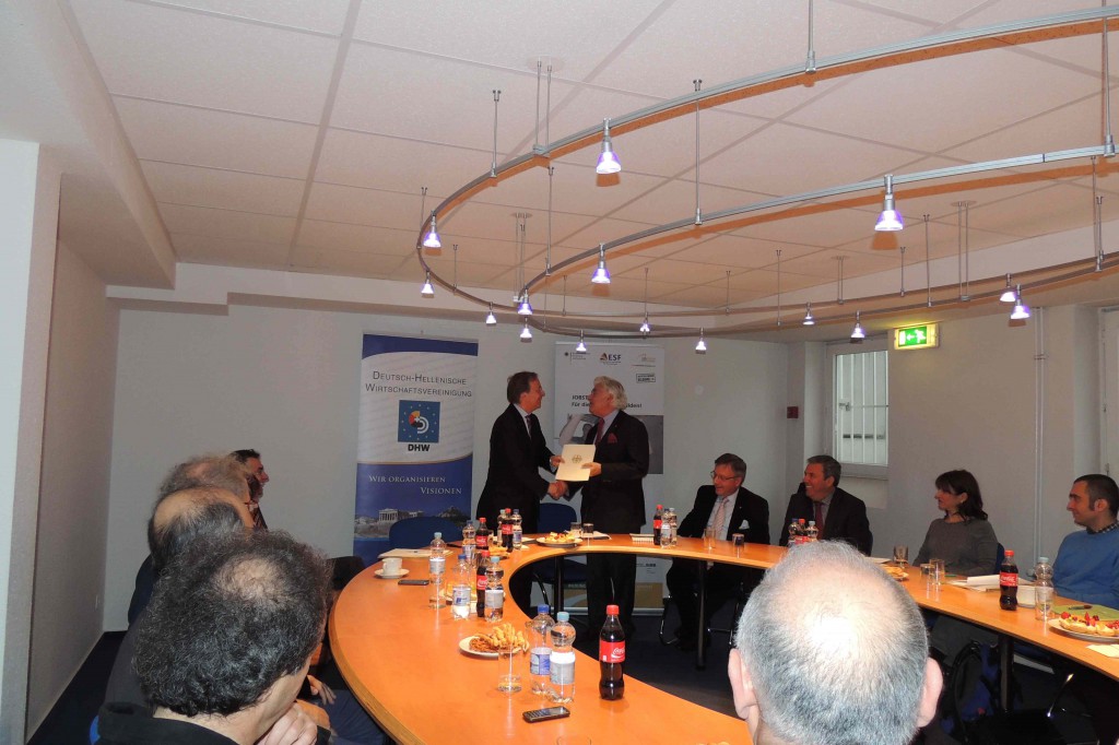  Ο Υφυπουργός Τόμας Ράχελ επιδίδει την απόφαση της Κυβέρνησης Μέρκελ στον ιδρυτικό Πρόεδρο του DHW Γιάννη Μπούρλο-Μάυ